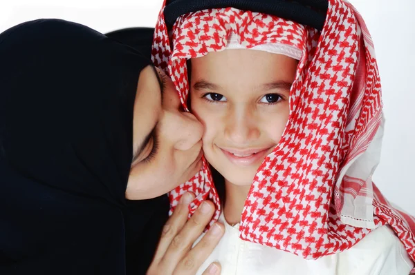 阿拉伯文穆斯林母亲亲吻她的小儿子 免版税图库图片