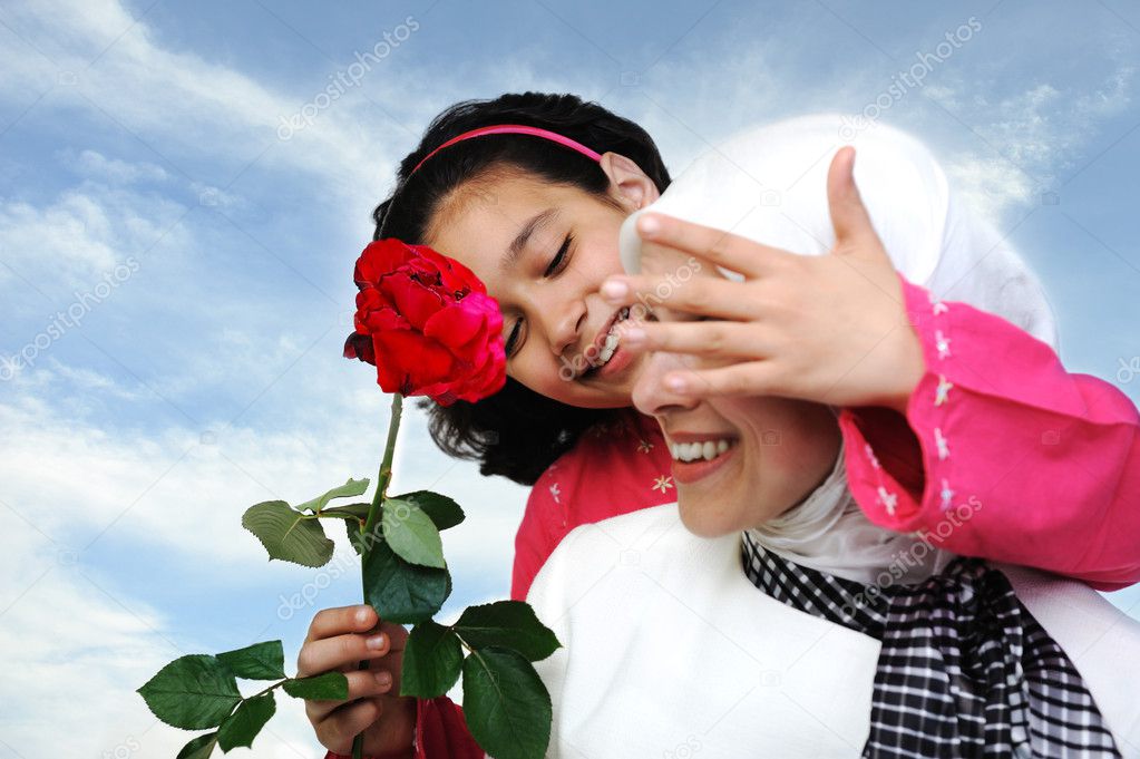 Muslim daughter giving present rose to mother