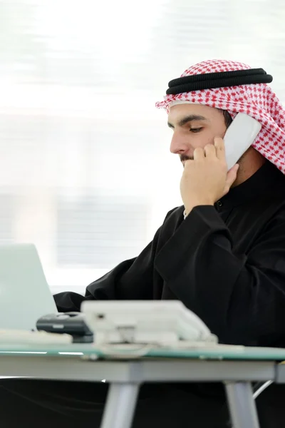 Portret mężczyzny inteligentnego arabski biznes za pomocą laptopa i rozmawia przez telefon — Zdjęcie stockowe