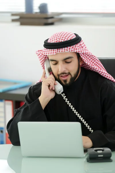Retrato de um homem de negócios árabe inteligente usando laptop e falando ao telefone — Fotografia de Stock