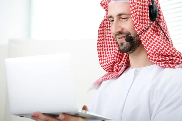 Retrato de um homem de negócios árabe inteligente usando laptop e fone de ouvido. Centro de atendimento. Apoio ao cliente. Serviço de Ajuda . — Fotografia de Stock