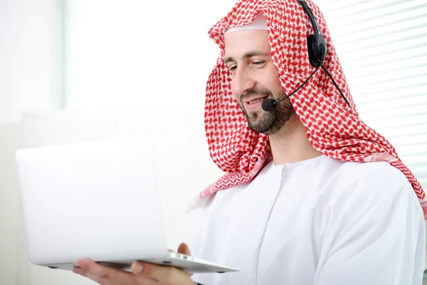 Portrét muže elegantní arabskou obchodní pomocí notebooku a sluchátka. Call centrum. oddělení podpory zákazníků. Helpdesk. — Stock fotografie