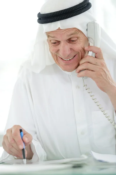 Retrato de un hombre de negocios árabe inteligente usando el ordenador portátil y hablando por teléfono —  Fotos de Stock