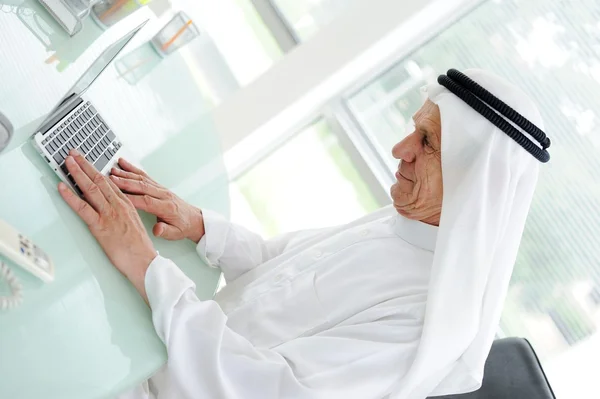 Portréja egy intelligens Arab üzleti ember használ laptop — Stock Fotó