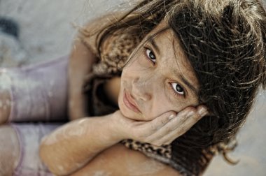 Poverty and poorness on the children face. Sad little girl. Refugee. War results. clipart