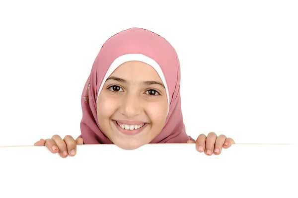 Kleines Mädchen, das ein leeres weißes Schild für Ihre Nachricht hält. gut für den Rand von Artikeln oder Webseiten. schönes arabisch-muslimisches Modell. isoliert auf weißem Hintergrund. — Stockfoto