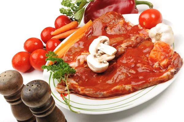 Prepating sliced meat with sauce on board with vegetables — Stock Photo, Image