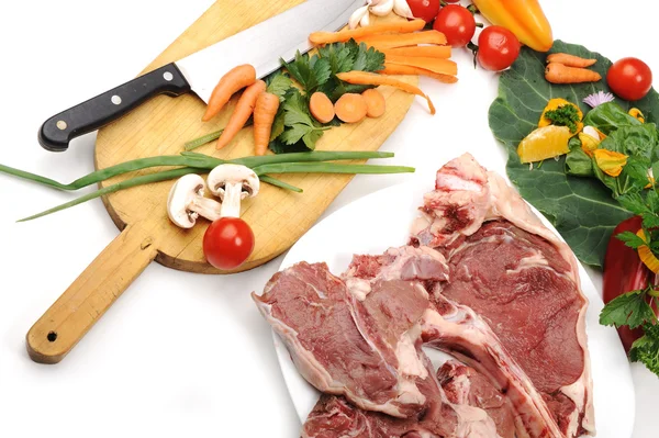 Carne fresca cruda cortada en cubitos a bordo con verduras —  Fotos de Stock