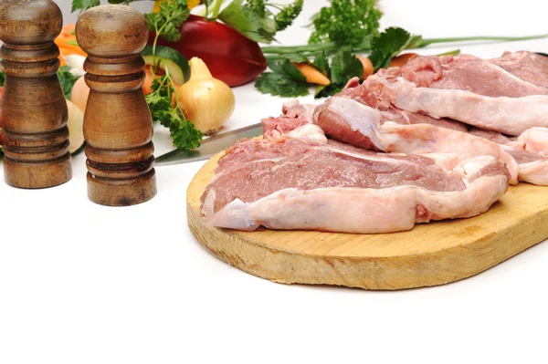 Raw fresh meat sliced in cubes on board with vegetables — Stock Photo, Image