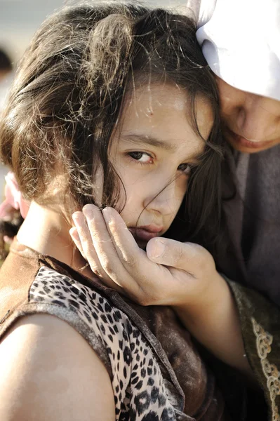 Bieda i ubóstwo na twarzy dzieci. smutne dziewczynki. uchodźcy. w ramionach matki muzułmańskich. — Zdjęcie stockowe