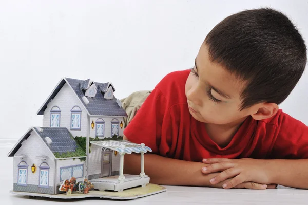 Маленький хлопчик з маленьким будинком, концептуальне зображення (будинок з паперу ) — стокове фото
