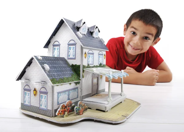 Kleine jongen met kleine huis, conceptuele foto (huis gemaakt van papier) — Stockfoto