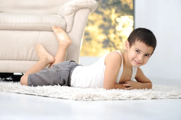 Niño feliz en el suelo en la sala de estar en casa — Foto de Stock