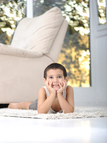 Criança feliz no chão na sala de estar em casa — Fotografia de Stock