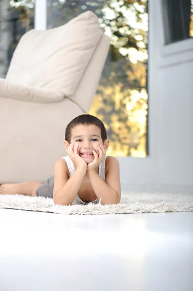 Ευτυχισμένο παιδί στον όροφο στο σαλόνι στο σπίτι — Φωτογραφία Αρχείου