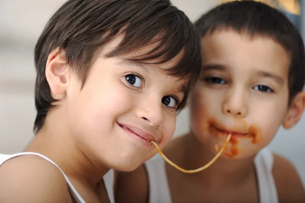 Two little boys eating spaghetti — Stock Photo, Image