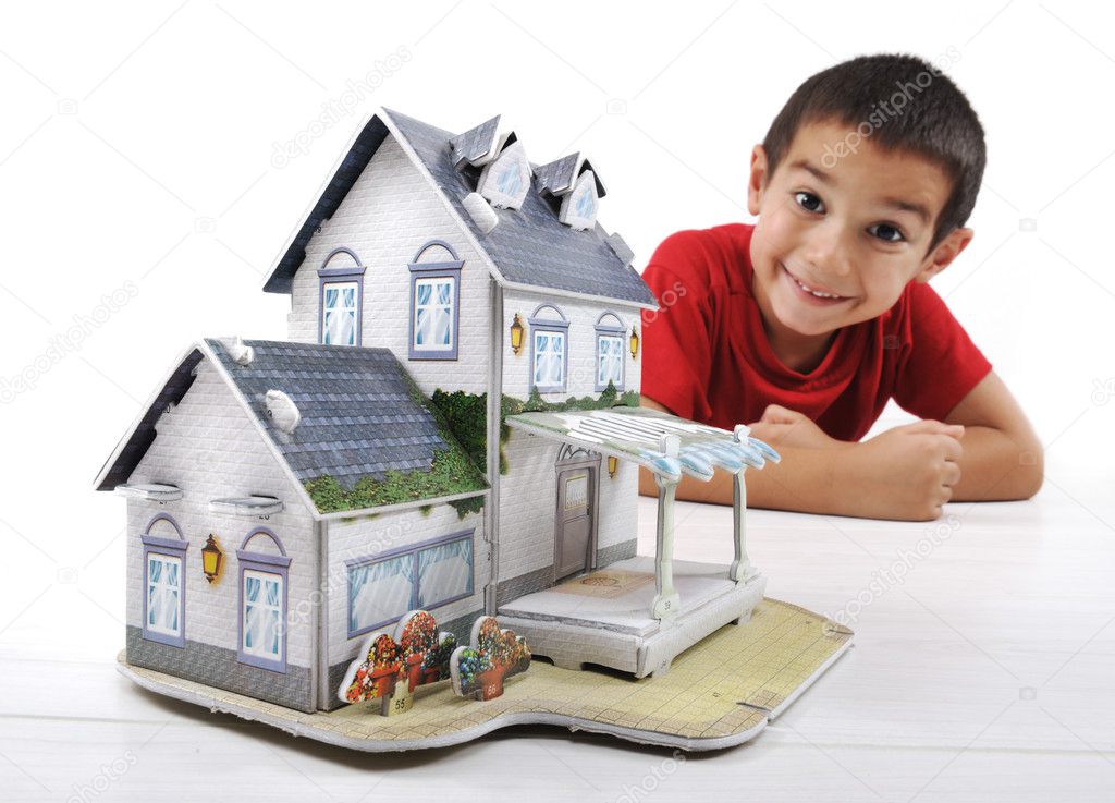 Little boy with little home, conceptual image (house made of paper)