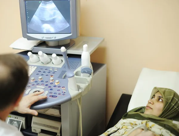Pregnant muslim woman getting ultrasound from doctor — Stock Photo, Image