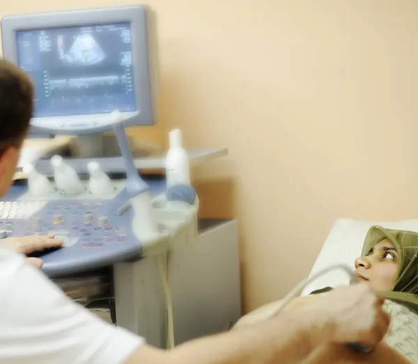 Mujer musulmana embarazada que recibe ultrasonido del médico —  Fotos de Stock