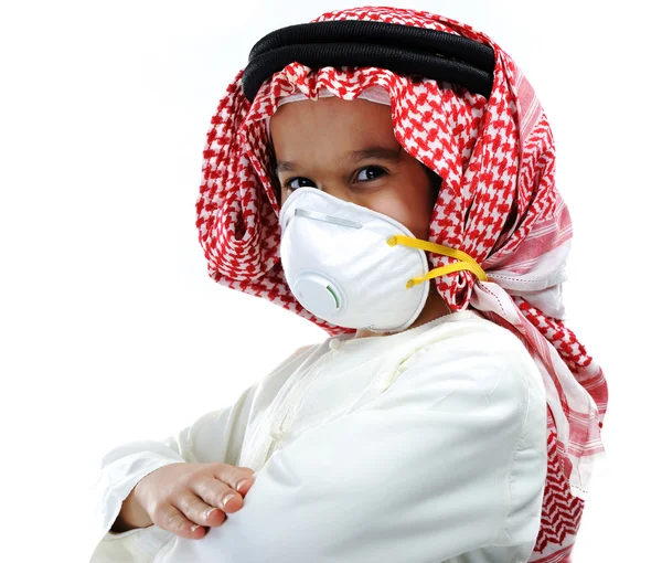 Bonito árabe muçulmano menino vestindo descartável máscara facial no branco fundo . — Fotografia de Stock