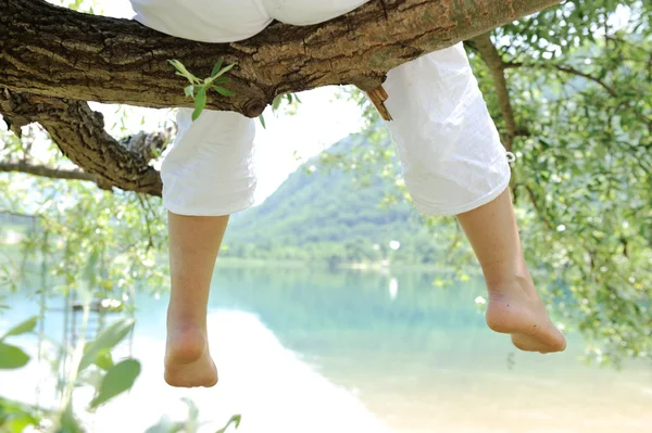 stock image Children sitting on a branch of a tree