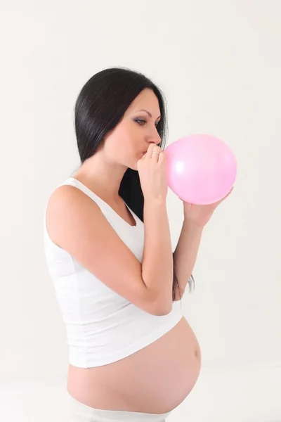 Беременная женщина с розовым шариком — стоковое фото