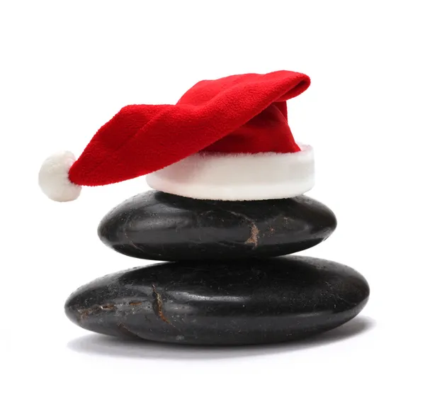 Stack of stones with red santa claus hat — Stock Photo, Image