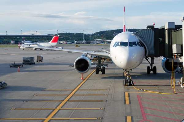 Avião em um aeroporto com corredor de passageiros — Fotografia de Stock