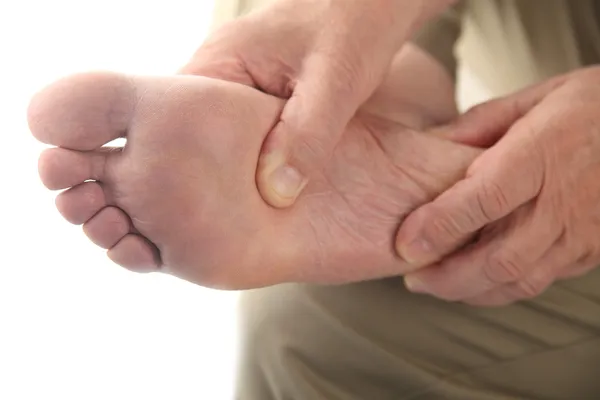Homem verifica seu pé dolorido — Fotografia de Stock