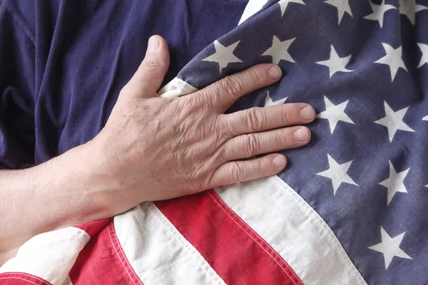 Amerikaanse vlag met de hand van een veteraan Rechtenvrije Stockafbeeldingen