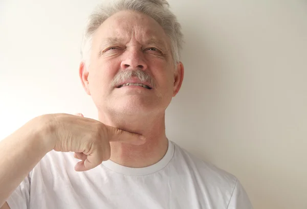 Starší muž gesta s prstem po krku — Stock fotografie