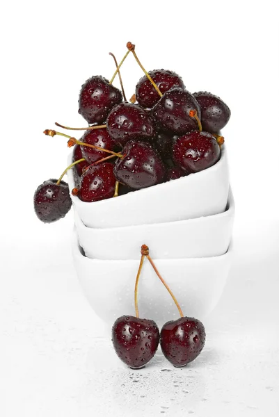 Fresh cherry berries in a stack of white ceramic bowls — Stock Photo, Image