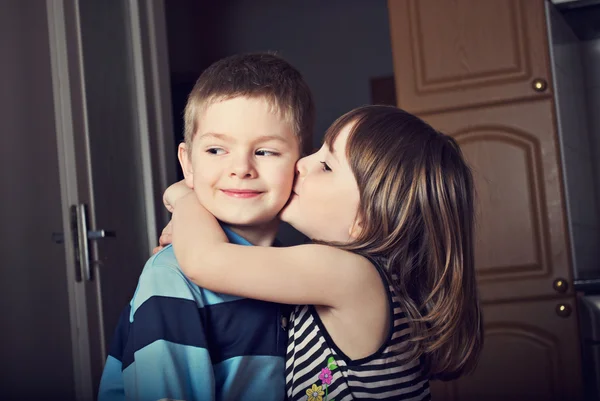 Очаровательная маленькая девочка целует мальчика — стоковое фото