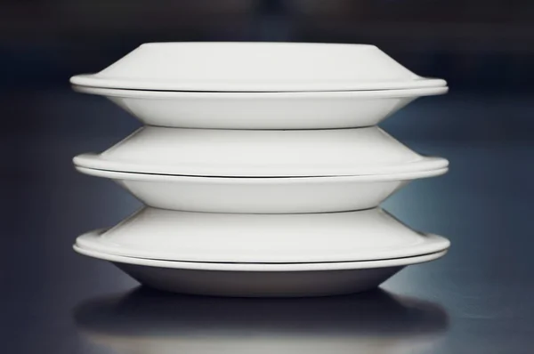 Una pila di piatti bianchi su un tavolo — Foto Stock