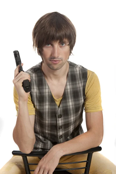 En ung man med en pistol i handen — Stockfoto