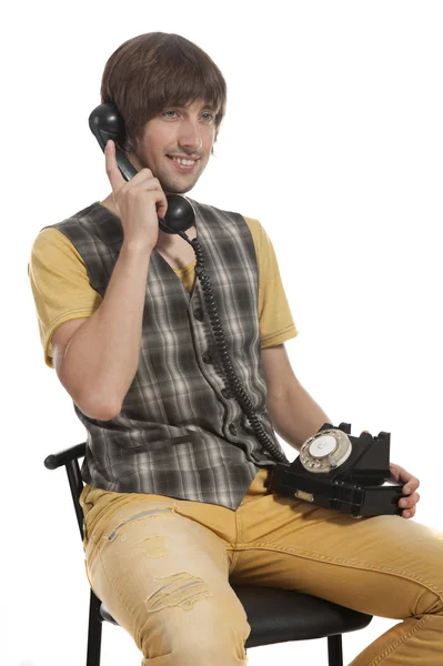 Un giovanotto con un vecchio telefono in mano — Foto Stock