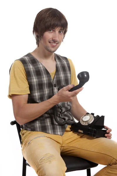 Ein junger Mann mit einem alten Handy in der Hand — Stockfoto
