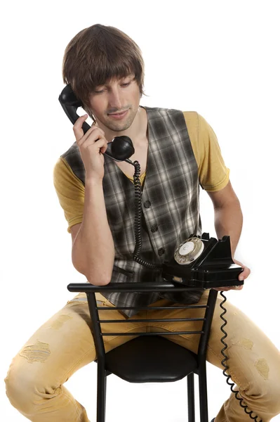 Un joven con un viejo teléfono en tus manos —  Fotos de Stock
