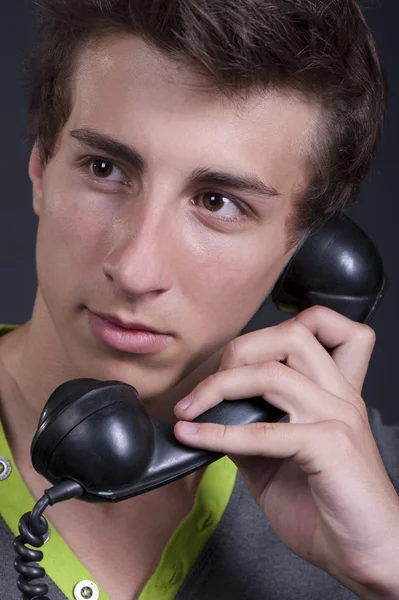 Ένας νεαρός άνδρας με ένα παλιό τηλέφωνο στα χέρια σας — Φωτογραφία Αρχείου