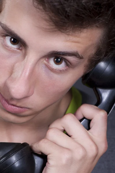 Een jonge man met een oude telefoon in uw handen — Stockfoto