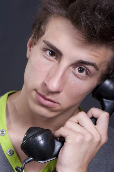 Egy fiatal ember, egy régi telefont a kezedben — Stock Fotó