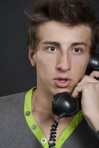 Um jovem com um telefone antigo — Fotografia de Stock