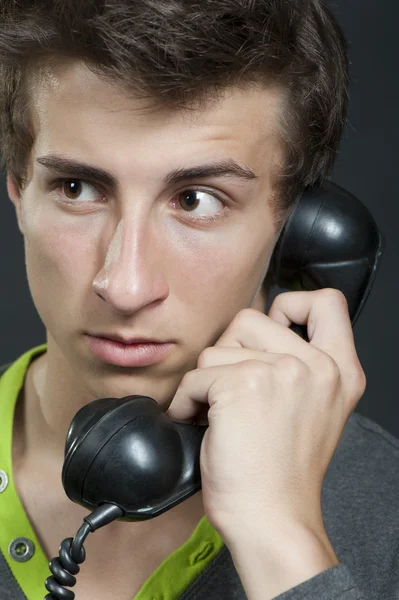 Un joven con un teléfono viejo — Foto de Stock