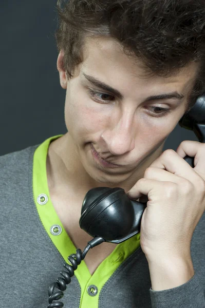 Um jovem com um telefone antigo — Fotografia de Stock