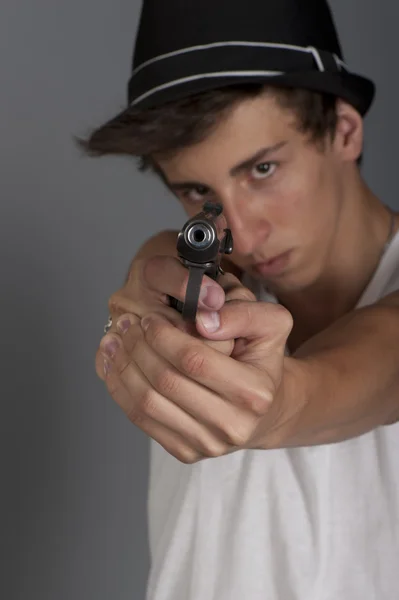 Молодий чоловік з пістолетом у руці. Фокус на руках за допомогою гі — стокове фото