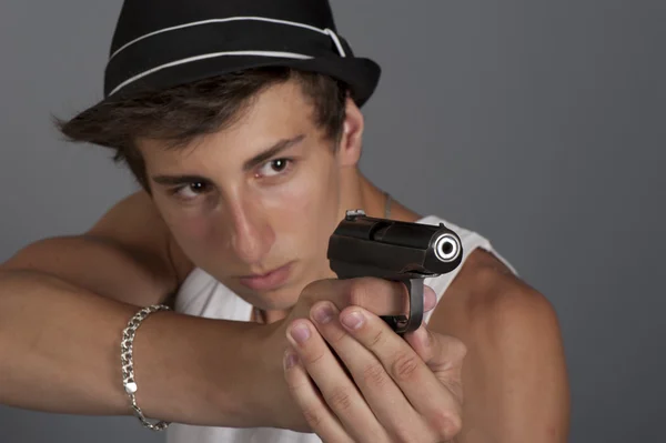 Ένας νεαρός άνδρας με ένα πυροβόλο όπλο στο χέρι του. επικεντρωθεί σε χέρια με το α gu — Φωτογραφία Αρχείου