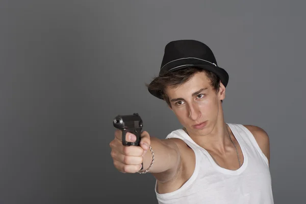 Um jovem com uma arma na mão — Fotografia de Stock