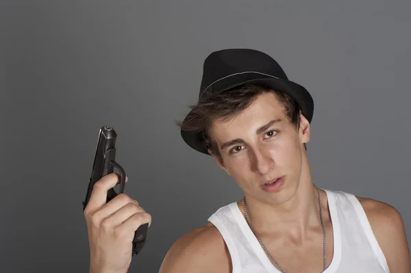 Ένας νεαρός άνδρας με ένα πυροβόλο όπλο στο χέρι του — Φωτογραφία Αρχείου