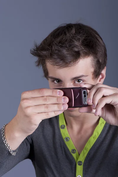 若い男は、携帯電話で写真を撮影します。 — ストック写真
