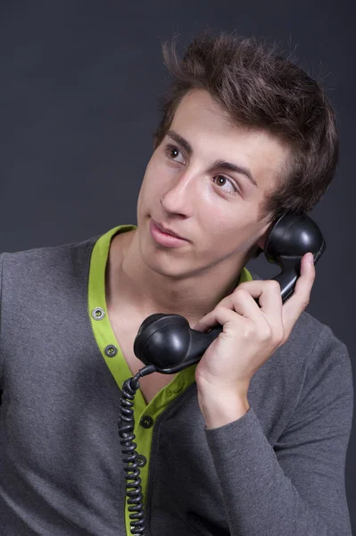 Jeune homme parlant sur le vieux téléphone et souriant — Photo